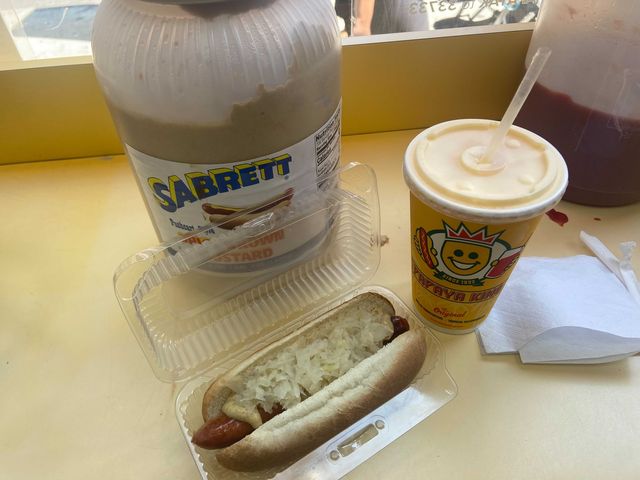 A hot dog and a drink in a paper cup.